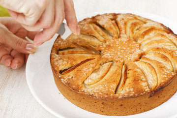 Housewife cut off piece of homemade apple cake