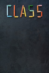 Text "Class" created with oil pastels on slate
