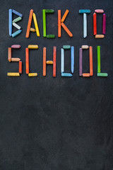 Text "Back to school" created with oil pastels on slate