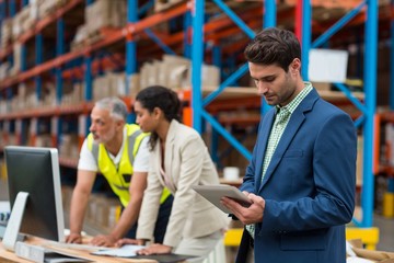 Warehouse managers and worker working together