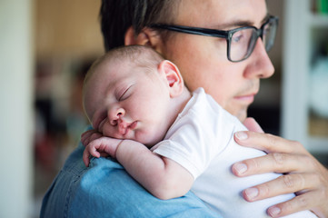 Close up of young father holding his newborn baby son - Powered by Adobe