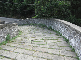 Fototapeta na wymiar Descent stone walkway of medieval bridge known as Ponte del Diavolo in Borgo a Mozzano, Italy