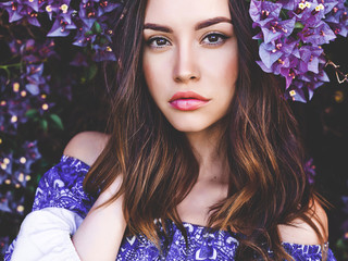 Beautiful young woman surrounded by flowers