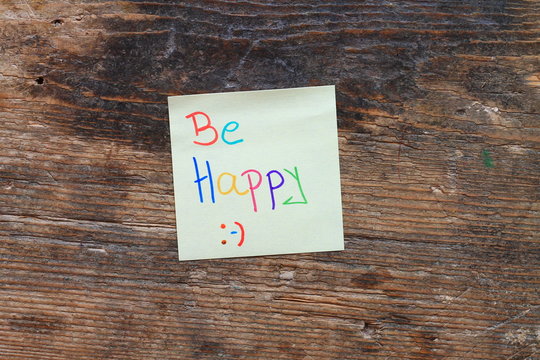 Motivation message Be happy on wooden table