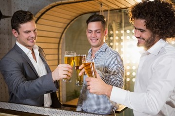 Group of friends toasting a glass of beer