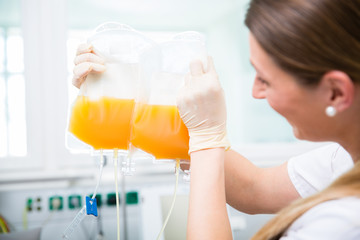 Arzthelferin vom Blutspendedienst mit einer Plasmaspende im Blutbeutel