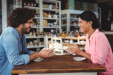 Couple smiling and holding coffee cup
