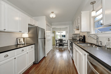 White kitchen storage combination and steel appliances