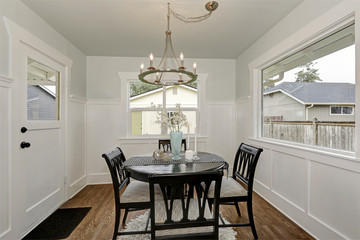 Dining black round table with four cushioned chairs. Dining room
