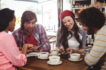 Group of friends using mobile phone and digital tablet