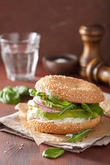 avocado sandwich on bagel with cream cheese onion cucumber arugu