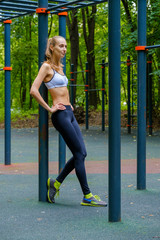 Young slim woman sports portrait on the training ground in a park