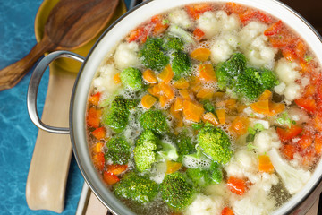 Pan cooking vegetarian soup with vegetables. Healthy eating.
