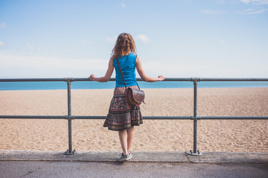 Young woman by railing on the beach