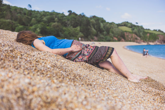 Young woman lying on dune