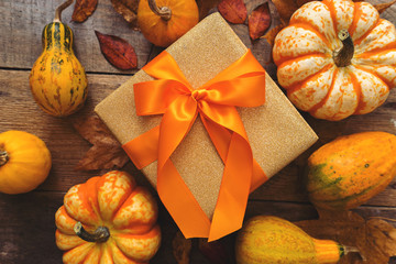 autumn gift in gold paper with orange ribbon