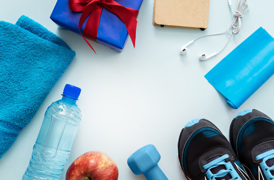 fitness equipment and gift on blue background
