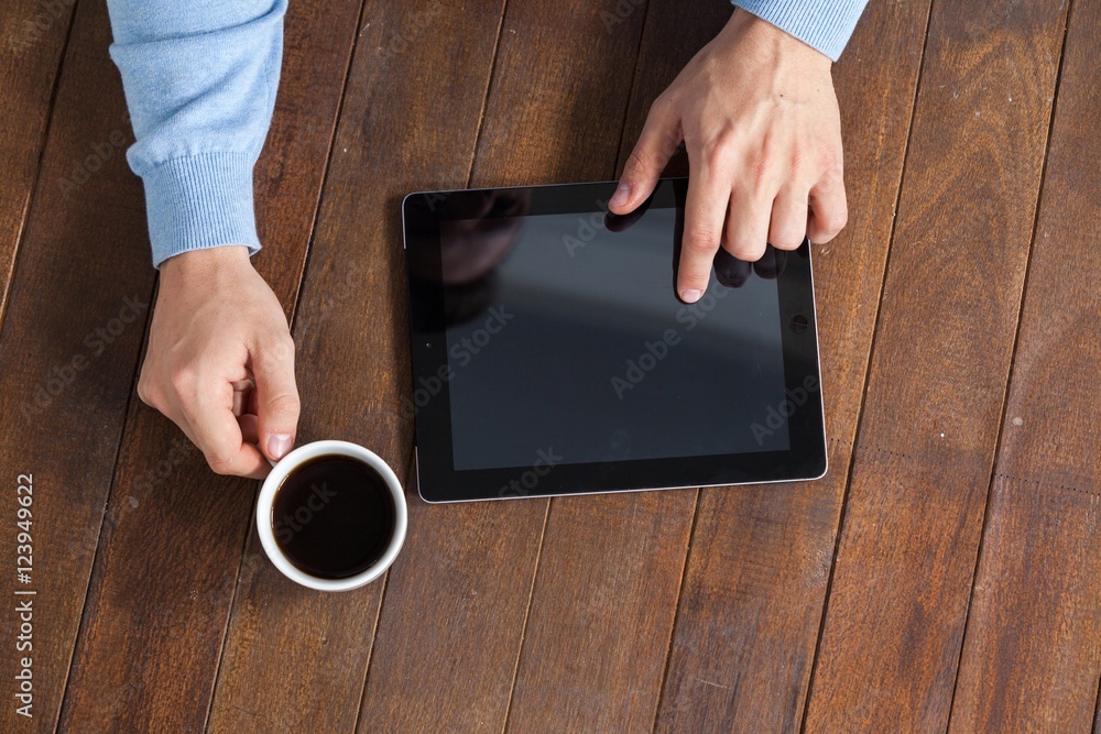 Poster Man using digital tablet while having cup of coffee