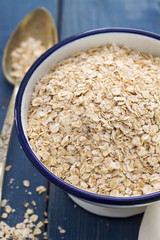 oat on white bowl on blue wooden background