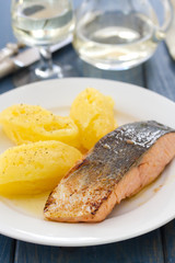 fried salmon with mashed potato on white dish on blue wooden background