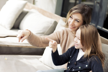 Happy mother and daughter pointing