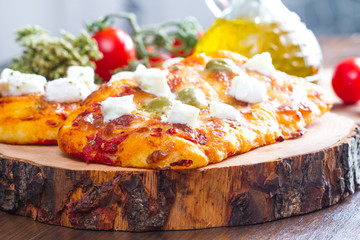 couple of pizza with olives and margherita on wood