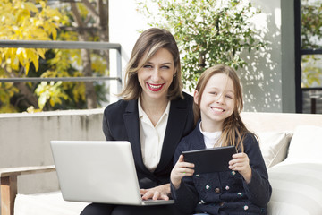 Mother and daughter with computer and tablet