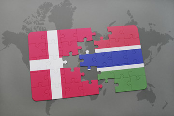 puzzle with the national flag of denmark and gambia on a world map background.