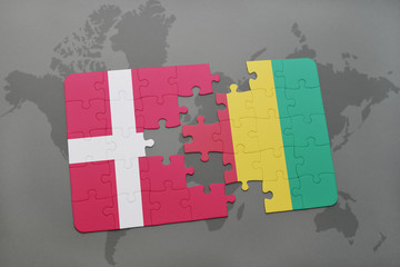 puzzle with the national flag of denmark and guinea on a world map background.