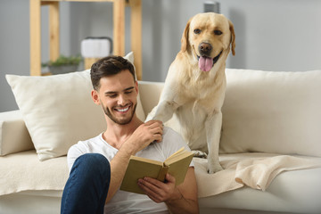 young man reading book to a dog