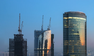 Tops of the three towers of different heights of skyscrapers. Concept development, construction and growth