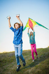Group of happy and smiling kids playingin with kite outdoor