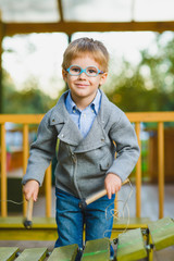 Fototapeta premium Close up portrait of cute boy playing xylophone outdoor