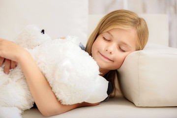 Carefree kid sleeping with bear toy