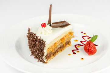 Beautiful cake in a plate with strawberries and red currants on a white background