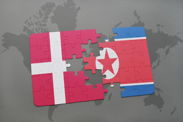 puzzle with the national flag of denmark and north korea on a world map background.