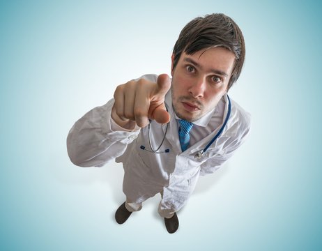 Young Doctor Is Pointing At You With Finger. View From Top.