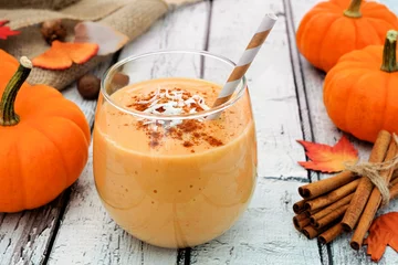 Selbstklebende Fototapete Milchshake Autumn pumpkin smoothie with coconut and cinnamon, still life on white wood