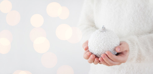 child holding white christmas bauble