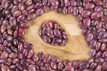 Pinto beans on wooden spoon. (Phaseolus vulgaris)