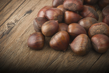 Fototapeta premium group of chestnuts on a wooden table