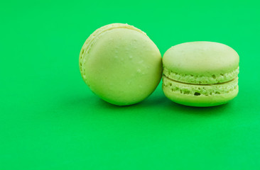 two green cake macaron on green background, maccarone sweet dessert