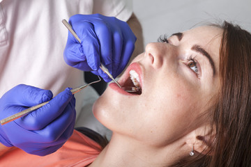 Zahnarzt kontrolliert die Zähne mit Spiegel und Sonde