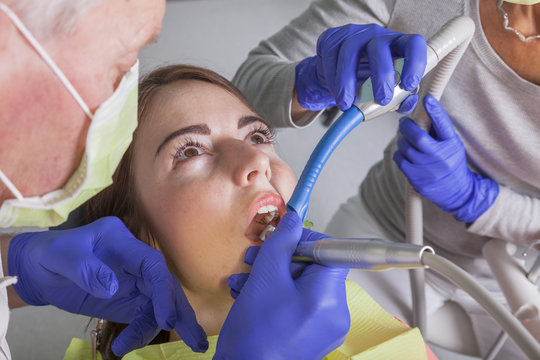 Zahnärztliche Behandlung mit Bohrer und Speichel Absauger