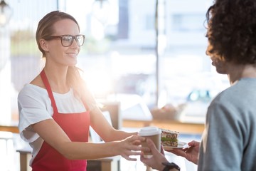 Waitress serving coffee and sandwich to customer 