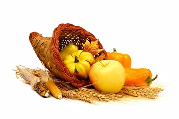 Thanksgiving cornucopia with yellow theme fruit and vegetables isolated on a white background