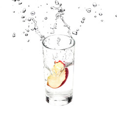 Fresh Apple is splashing in glass with pure water isolated on white background