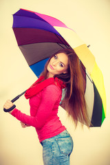 Woman standing under multicolored umbrella