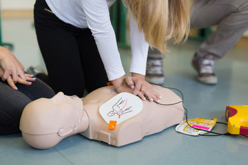 First aid cardiopulmonary resuscitation course using automated external defibrillator device, AED. - obrazy, fototapety, plakaty