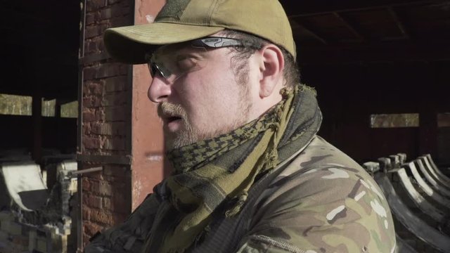 Military smoking a cigar near a building